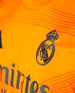 104741175-Camiseta-visitante-Adidas-Real-Madrid-anaranjada-2024-25