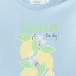 Blusa-celeste-con-estampado-de-limones-para-niña-104831927